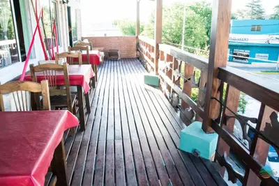 a deck of a restaurant with tables and chairs at El Quincho in Santa Rosa de Calamuchita