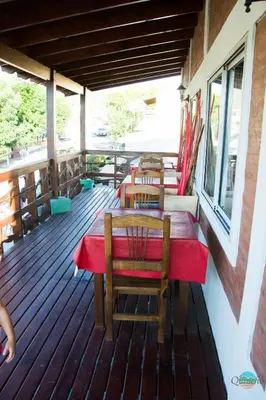 a restaurant with tables and chairs on a deck at El Quincho in Santa Rosa de Calamuchita