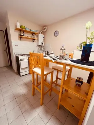 a kitchen with a table and two chairs and a counter at Departamento moderno Zona centro in Cordoba