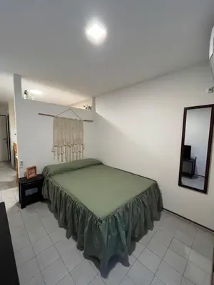 a bedroom with a green bed and a mirror at Departamento moderno Zona centro in Cordoba