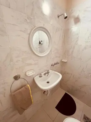 a white bathroom with a sink and a mirror at Departamento moderno Zona centro in Cordoba