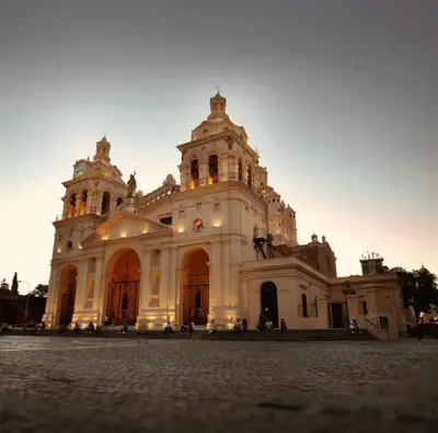 a large white building with a sunset behind it at HERMOSO DEPARTAMENTO a 3 cuadras del PATIO OLMOS Dos dormitorios in Cordoba
