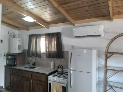 a kitchen with a stove and a white refrigerator at Colinas del Mirador in Villa Carlos Paz