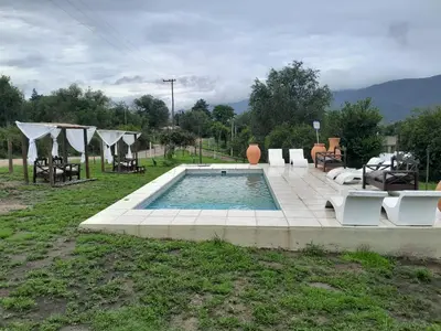 a swimming pool with some chairs and a table at Colinas del Mirador in Villa Carlos Paz