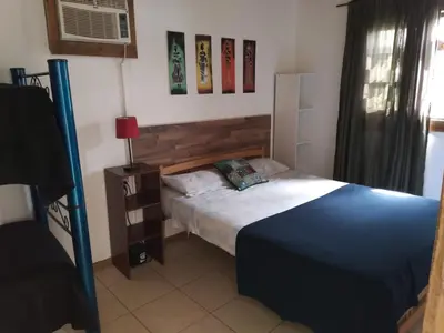 a small bedroom with a bed and a fan at Colinas del Mirador in Villa Carlos Paz