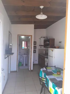 a kitchen with a table and a kitchen with a refrigerator at Colinas del Mirador in Villa Carlos Paz
