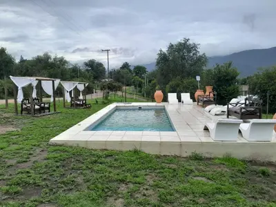 a swimming pool with some chairs and a table at Colinas del Mirador in Villa Carlos Paz