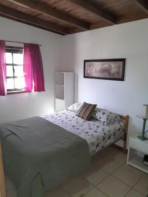 a bedroom with a bed and a window at Colinas del Mirador in Villa Carlos Paz