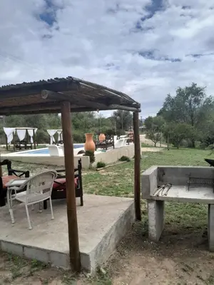 a pavilion with a table and a bench in a field at Colinas del Mirador in Villa Carlos Paz