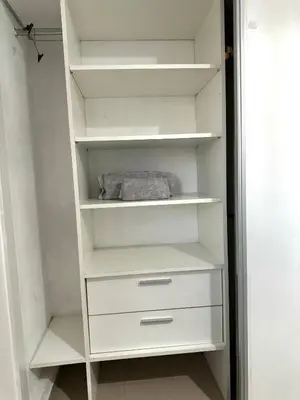 a white closet with white shelves in a room at Departamento Altas in Cordoba