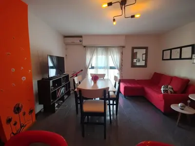 a living room with a red couch and a table at Departamento Urquiza 269 in Cordoba
