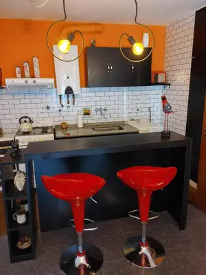 a kitchen with two red stools in front of a counter at Departamento Urquiza 269 in Cordoba