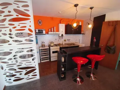 a kitchen with orange walls and red stools in it at Departamento Urquiza 269 in Cordoba