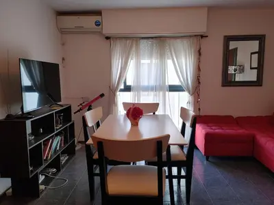 a living room with a table and a red couch at Departamento Urquiza 269 in Cordoba