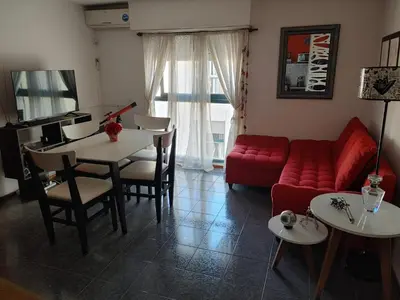 a living room with a red couch and a table at Departamento Urquiza 269 in Cordoba
