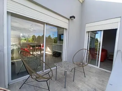 a patio with two chairs and a table on a balcony at Terrazas de Yacanto in Villa Yacanto