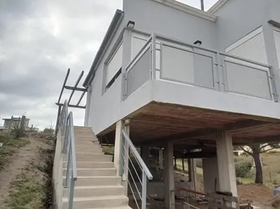 a building with a balcony on the side of it at Terrazas de Yacanto in Villa Yacanto