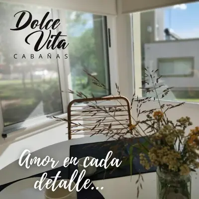 a table with a vase of flowers and a window at Dolce Vita in Merlo