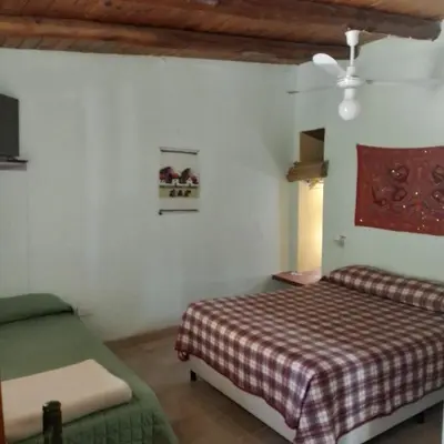 a bedroom with a bed and a chair in it at Cabañas Cangas de Onis MAYU SUMAJ in Villa Icho Cruz