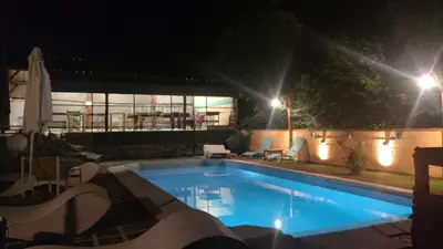 a large swimming pool at night with lights at Cabañas Cangas de Onis MAYU SUMAJ in Villa Icho Cruz