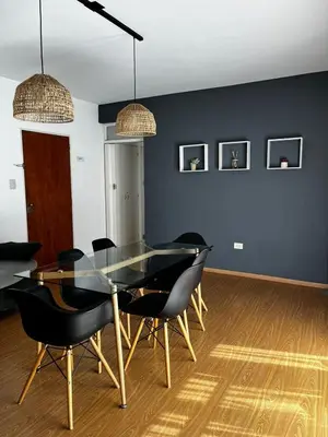 a dining room with a glass table and black chairs at El Abrojal 3 - Dpto 1 dormitorio a 3 cuadras Patio Olmos in Cordoba