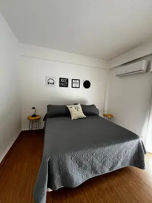 a bedroom with a bed and two end tables at El Abrojal 3 - Dpto 1 dormitorio a 3 cuadras Patio Olmos in Cordoba