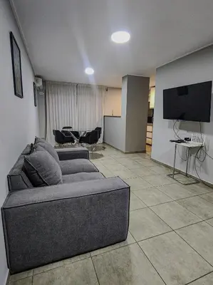 a living room with a couch and a flat screen tv at Loft General Paz in Cordoba