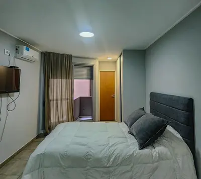 a bedroom with a large bed and a window at Loft General Paz in Cordoba