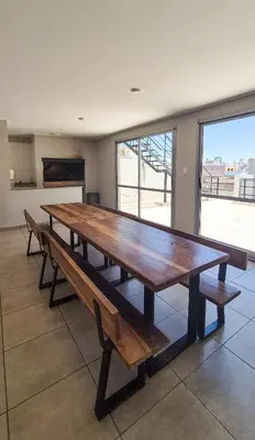 a large wooden table in a room with benches at Loft General Paz in Cordoba