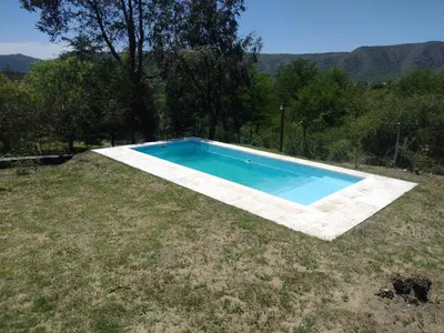 a swimming pool in the middle of a yard at Cabaña de piedra Los Crespines in San Antonio de Arredondo