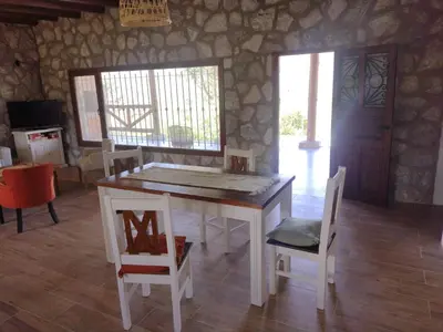 a dining room with a table and some chairs at Cabaña de piedra Los Crespines in San Antonio de Arredondo
