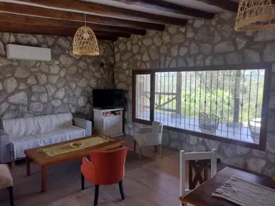 a living room with a couch and a table at Cabaña de piedra Los Crespines in San Antonio de Arredondo
