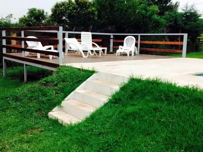 a patio with white chairs and a bench at Jasy Cabañas in Potrero de Garay