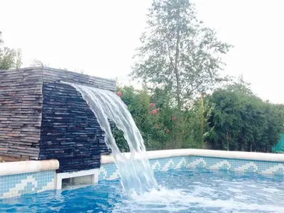 a water fountain in a swimming pool at Jasy Cabañas in Potrero de Garay