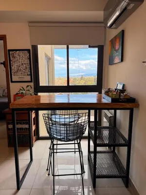 a kitchen with a table with two chairs and a window at Buena Vista in Alta Gracia