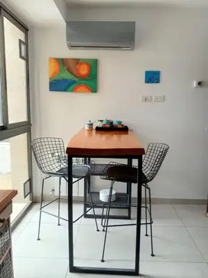 a table and chairs in a room with a painting at Buena Vista in Alta Gracia