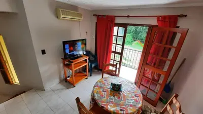 a living room with a table and a television and a table and chairs at Ofelia, departamento en Alta Gracia. in Alta Gracia