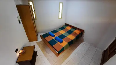 a bedroom with a bed with a colorful blanket at Ofelia, departamento en Alta Gracia. in Alta Gracia