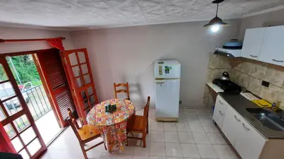 a kitchen with a small table and a refrigerator at Ofelia, departamento en Alta Gracia. in Alta Gracia