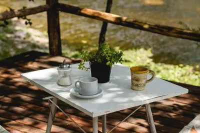 a table with two cups and a potted plant on it at HOSTERÍA ARROYO CRISTAL in Cavalango