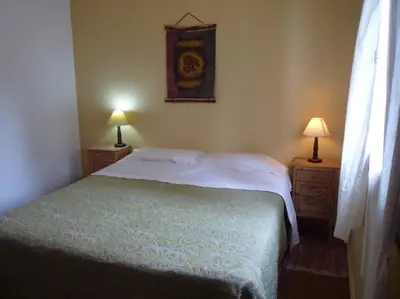 a bedroom with a bed and two lamps on tables at HOSTERÍA ARROYO CRISTAL in Cavalango