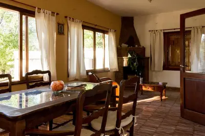 a living room with a table and chairs and windows at HOSTERÍA ARROYO CRISTAL in Cavalango