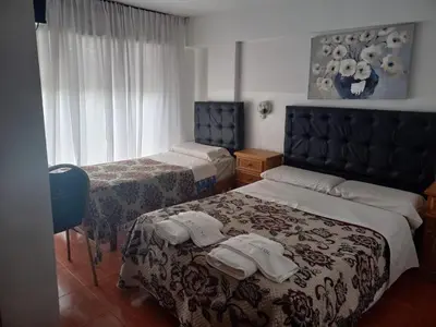 a hotel room with two beds with towels on them at Hotel Bristol in Cordoba
