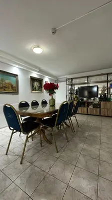 a dining room with a table and chairs and a television at Hotel Bristol in Cordoba
