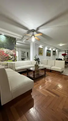 a living room with white couches and a ceiling fan at Hotel Bristol in Cordoba