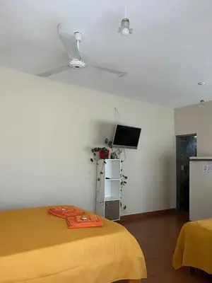 a bedroom with a yellow bed and a tv at Casa Lavanda in Embalse
