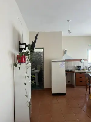 a kitchen with a white refrigerator and a kitchen with a table at Casa Lavanda in Embalse