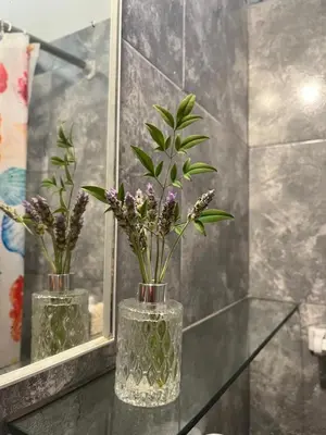 two vases with flowers in them on a glass table at Casa Lavanda in Embalse
