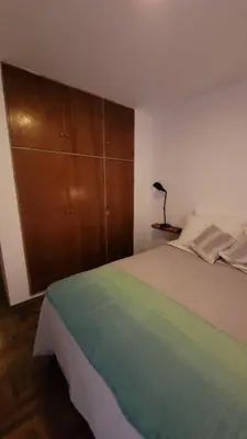 a bedroom with a bed with a wooden cabinet at Estancia Nueva Córdoba II in Cordoba