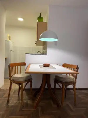 a kitchen with a table and two chairs and a refrigerator at Estancia Nueva Córdoba II in Cordoba